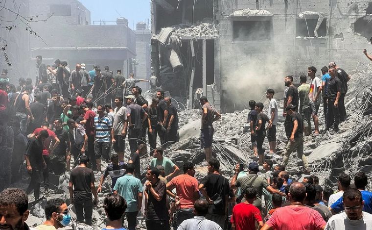 FOTO: Decenas de palestinos buscan víctimas en las ruinas de un edificio destruido. (NA)